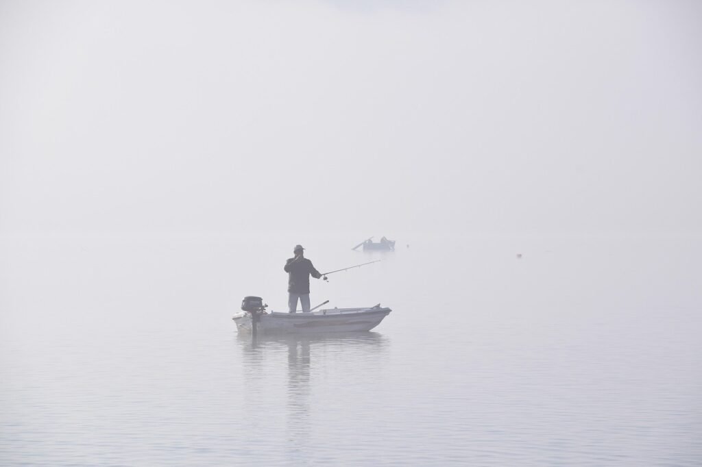 Barco pesquero navegando en un lago con niebla representando la presión de no saber qué hacer con tu vida