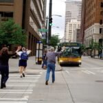 Persona caminando sola con prisa por la ciudad al atardecer, simbolizando la sensación de ir tarde en la vida